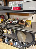 Metal shelving with tools, paint cans, dust-collection hood, pet bowl