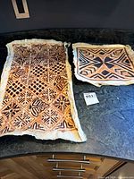 Both tapa cloth panels displayed on countertop