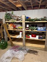 Wide shot of shelving with various holiday décor, candles, demijohn, reed bundles