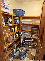 Overall view of shelving with cleaning supplies, paper goods, storage bins