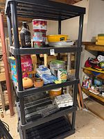 Full view of black plastic shelving loaded with various kitchen items as listed