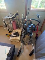 Group showing walkers, baby gate, exercise mat, hand weight, basket and cushion