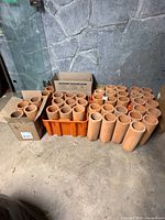 group of terracotta cylinders in orange crate and boxes