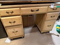 Front view showing six drawers, brass hardware, central open kneehole