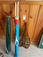All items grouped: pair of snowshoes, blue bag with poles, green mat