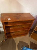 Front view of wooden bookcase showing shelves and wear