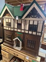 Front view of wooden Tudor-style dollhouse on dresser