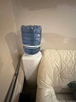 Full view of blue 5-gallon bottle showing dented top