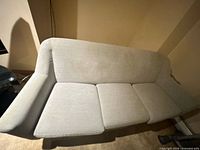 Front view of light gray three-seat sofa showing cushions and arm design