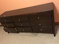 Front view of dresser with drawers partially open, shows nine-drawer layout and exterior wear