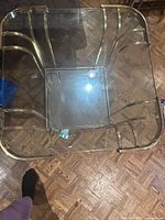 Square glass coffee table top view showing brass frame and mirrored center