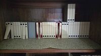 Shelf view showing two rows of BASF white plastic numbered slipcases and grey boxes