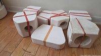 Group of seven white plaster molds bound by rubber bands