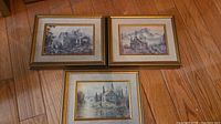 All three framed Keirstead prints laid out on hardwood floor