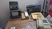 Lot overview showing CRT TV, small radio, radio-cassette player, two telephones