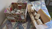 two boxes containing assorted mugs cups and glasses