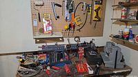 Workbench with pegboard displaying hand tools and bench-top sander
