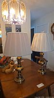 Pair of brass table lamps with shades displayed on table