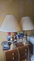 Both brass table lamps with shades on dresser