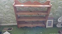 Front view of solid wood bookshelf showing four shelves and scalloped details