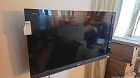 Front view of Sony Bravia TV powered on, wall-mounted