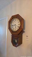 Front view of Spirit regulator wall clock hanging on wall