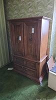 Front view of closed armoire showing doors and drawers