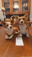 Front view of both resin corgi figurines on table