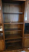 Front view of empty five-shelf walnut veneer bookcase