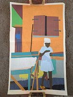 Full view of unframed screen print held by clips
