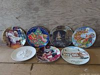 Seven assorted Christmas plates lined up for overall view