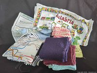 Group shot showing all towels and cloths, including printed map towels and stack of crocheted cloths