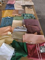 Overall lot showing all folded fabric pieces on table