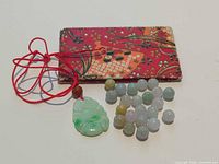 Group shot showing pendant on cord, loose beads, and fabric pouch