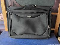Front view of black Jaguar garment bag showing exterior zip pocket and logo badge