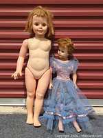Full view of both dolls standing side by side to show size difference and overall condition