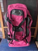 Front view of Olympia pink/gray rolling duffel backpack