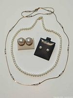 Full view of both necklaces and both earring pairs