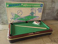 Full view of pool table with cue, balls, and box
