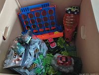 Overview of box contents including Connect Four board, cars, track pieces, dinosaur figures