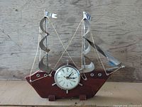 Front view of United nautical ship mantle clock showing hull, dial, sails