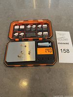 digital scale showing four amethyst stud earrings totaling 1.40 g