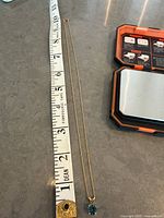 Necklace alongside measuring tape showing ~18 in length