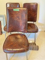 Three brown vinyl chairs front view