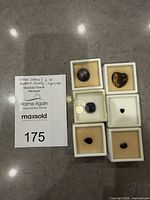 Six gemstone display boxes with stones