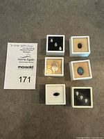Six gem display boxes showing all ten loose stones next to lot card