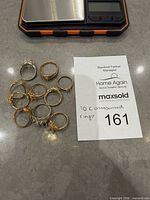 All ten rings beside scale and lot card