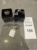 Overview of four sterling silver rings on boxes and tags