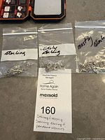 Three zip bags of silver-tone findings labeled sterling, likely sterling and mostly sterling