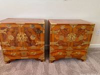 Front view of both nightstands with doors closed showing burl veneer and brass hardware